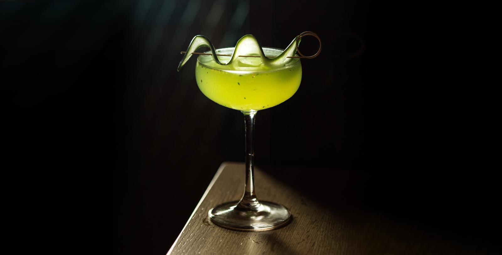 Cocktail called Green Goddess with cucumber garnished
